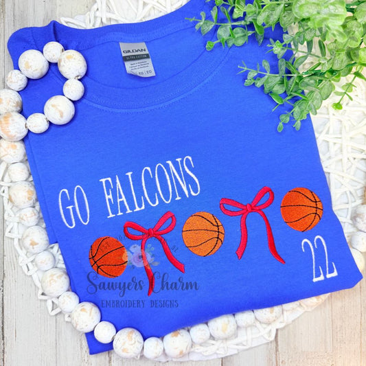 Blue t-shirt with 'GO FALCONS' text and basketball graphics on a decorative background