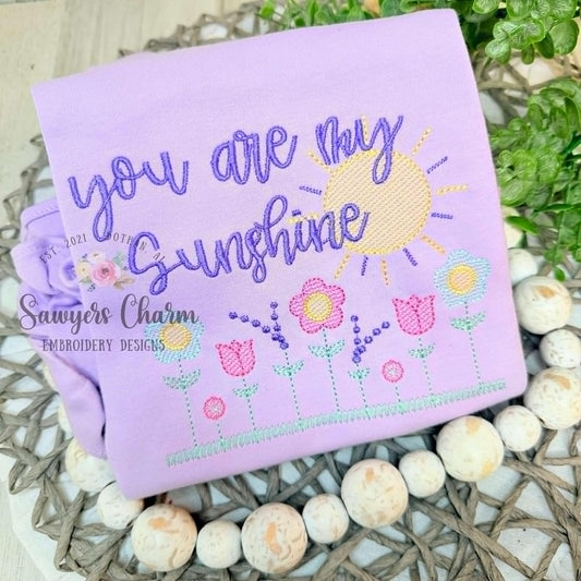 Row of wildflowers in grass with sunshine, sketch stitch machine embroidery design, spring flowers, tulip, daisy, lavender, summer outdoors